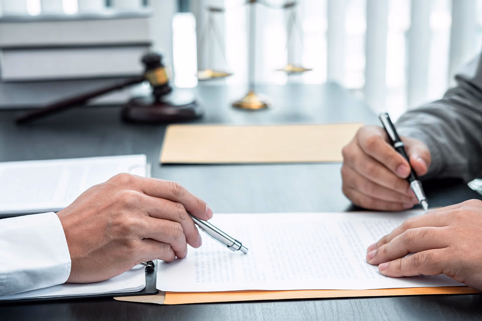 Professionals reviewing compliance documentation at a desk.